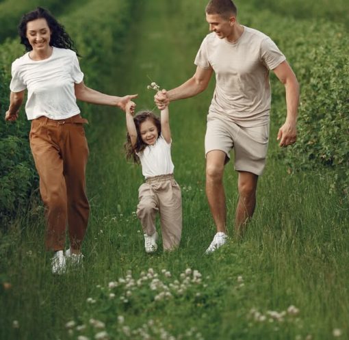 Joyful family enjoying a fun day outdoors in a green field, epitomizing togetherness and happiness.